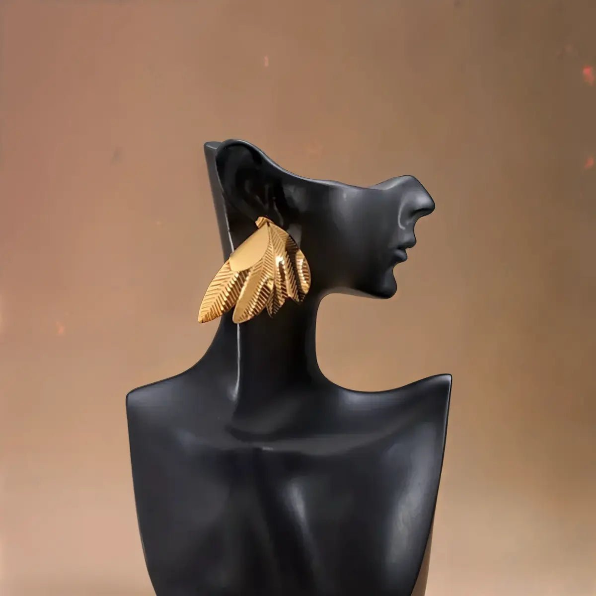 Boucles dorées design inspiré des ailes, élégantes et résistantes.