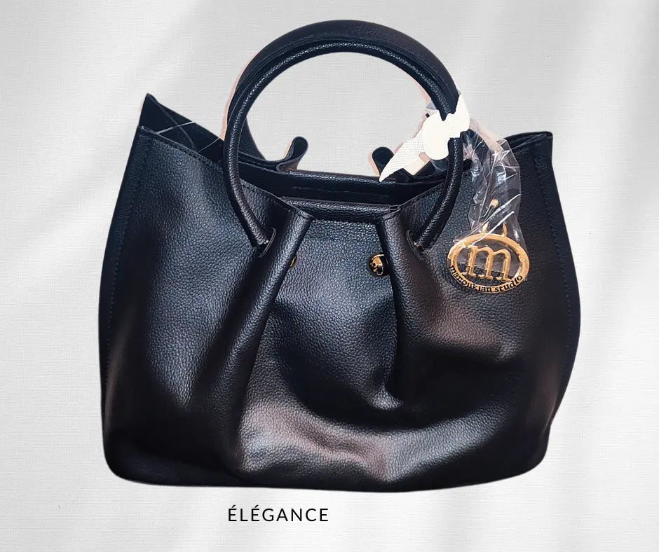 Sac à main Manoukian Camille noir avec bandoulière amovible. Élégant et chic, ce sac à main pour femme allie style et praticité. Son design tendance et spacieux le rend parfait pour les femmes modernes. Un sac noir intemporel qui s'adapte à toutes les occasions et ajoute une touche d’élégance à vos tenues.