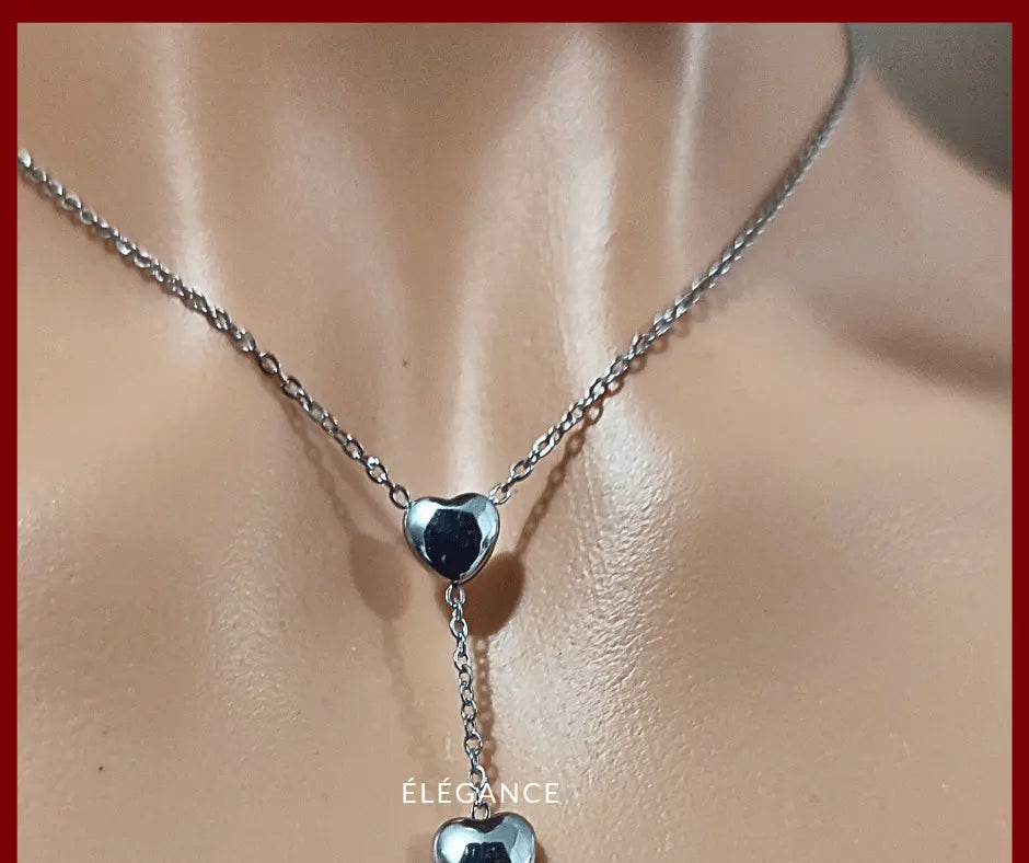 Collier long romantique en acier inoxydable doré, orné de trois cœurs pour un look tendre.

