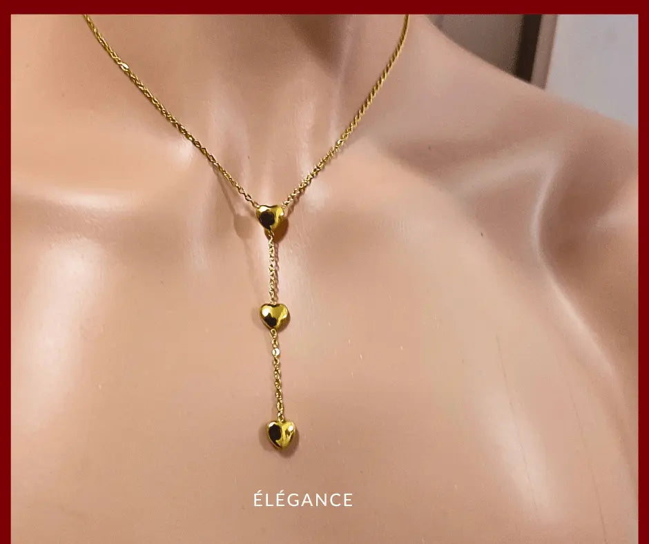 Collier long romantique en acier inoxydable doré, orné de trois cœurs pour un look tendre.