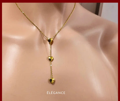 Collier long romantique en acier inoxydable doré, orné de trois cœurs pour un look tendre.