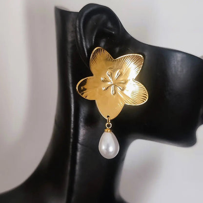 Boucles d’oreilles dorées style fleur avec perle pendante, allure féminine et moderne.