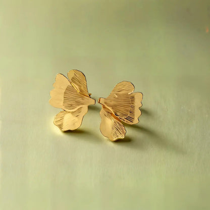 Boucles demi-pétale dorées en acier inoxydable, style moderne et raffiné.