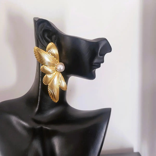 Boucles Golden Wings dorées en acier inoxydable, design papillon sculpté et perle centrale.