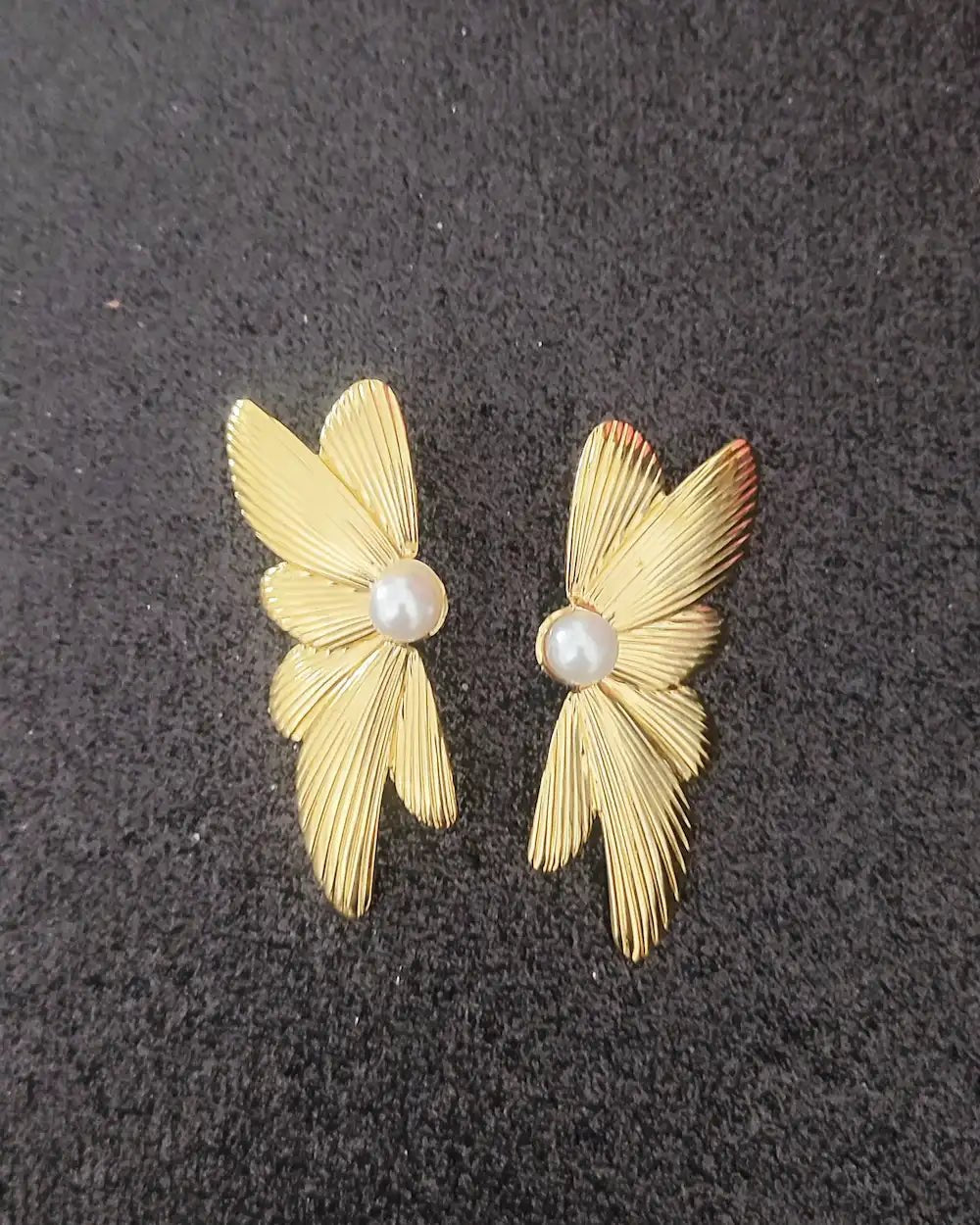 Bijou papillon doré avec perle, effet nervuré élégant et moderne.