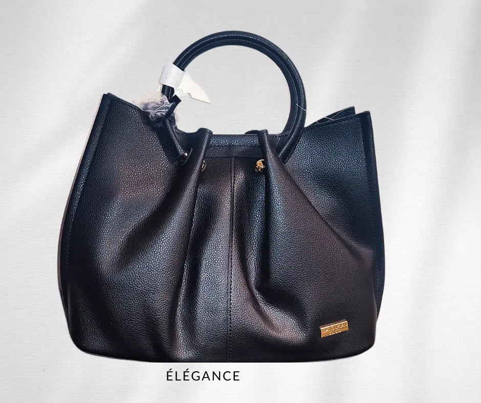 Sac à main Manoukian Camille noir avec bandoulière amovible, chic et élégant, idéal pour toutes les occasions. Ce sac de marque Manoukian pour femme allie style et praticité avec un grand espace de rangement. Parfait pour les femmes modernes qui recherchent un sac tendance et original, ce modèle noir s'adapte facilement à toutes vos tenues.