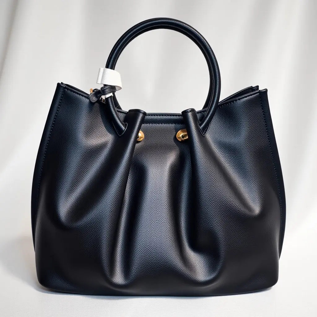 Sac à main Manoukian Camille noir avec bandoulière amovible. Ce sac chic et pratique pour femme est idéal pour les occasions quotidiennes ou spéciales. Élégant, spacieux et tendance, il s'adapte à toutes vos tenues. Un sac noir polyvalent et original, conçu pour les femmes modernes. Achetez ce sac à main ches élégance simplement pour un style raffiné